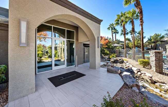A modern house entrance with a stone wall and a black doormat.