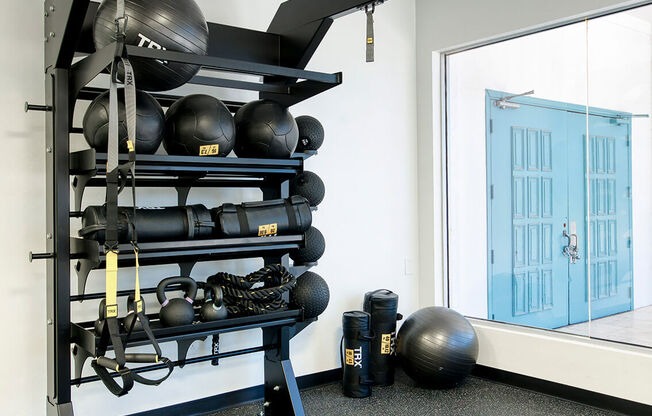 a gym with weights and a rack of balls and a window at Presidio Palms Apartments, Tucson, AZ, 85701