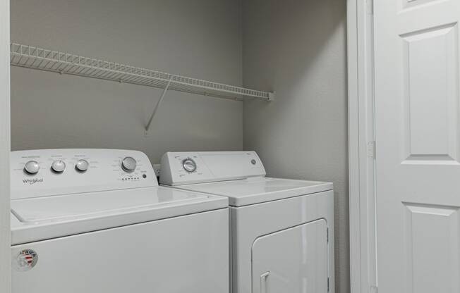 a white washer and dryer in a room with a white door