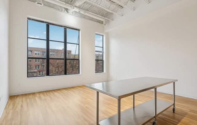 A room with a table and a window overlooking a building.