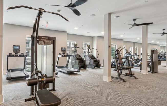 a gym with cardio machines and other exercise equipment in a building