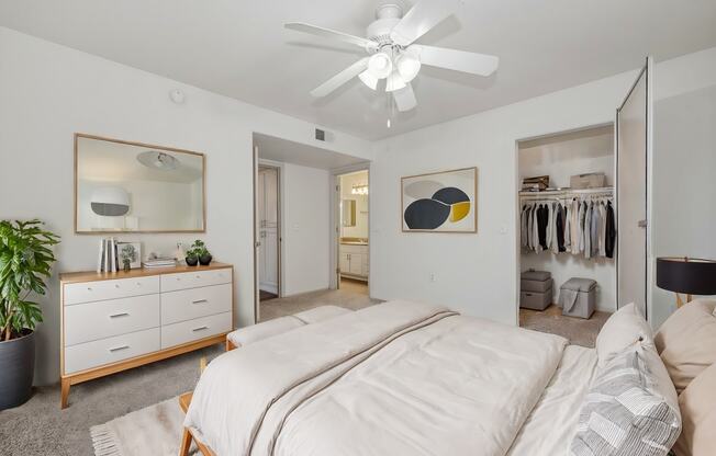 a bedroom with a large bed and a ceiling fan