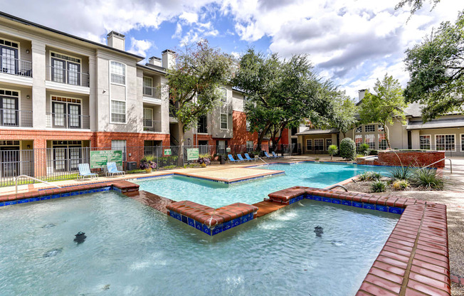 A swimming pool surrounded by a brick building.