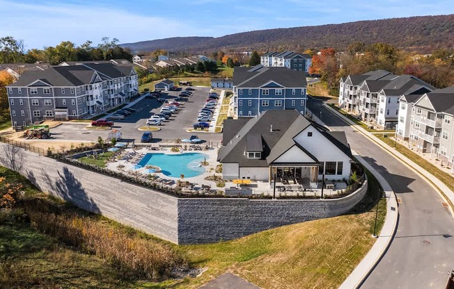 A large resort with a swimming pool and a parking lot.