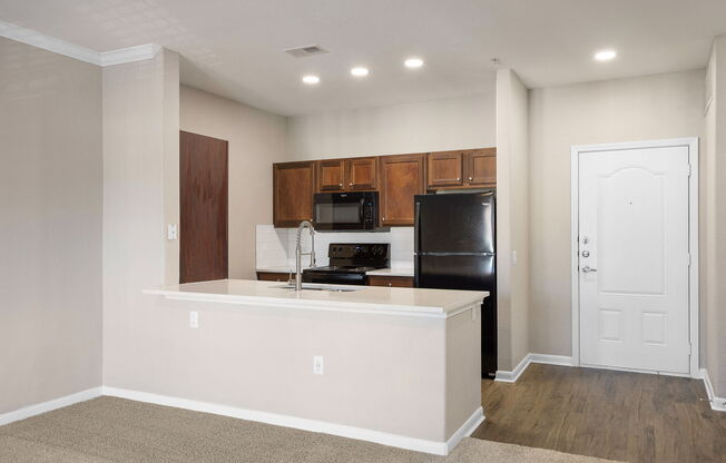 a kitchen with a large island and a black refrigerator at The Fairways at Star Ranch, Hutto, Texas