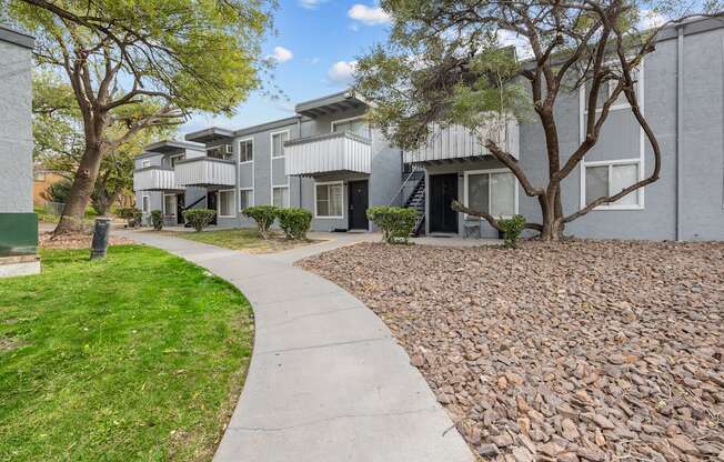 A residential area with apartment buildings and a sidewalk.