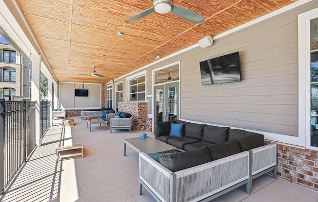 a covered porch with a couch and a coffee table