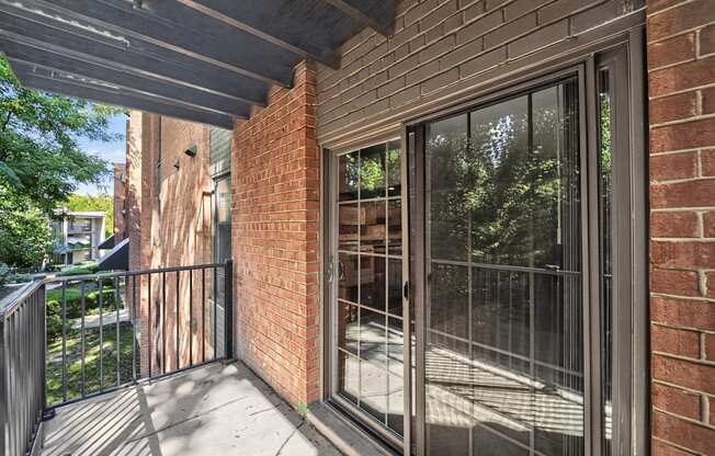 A balcony with a black railing and a glass door.