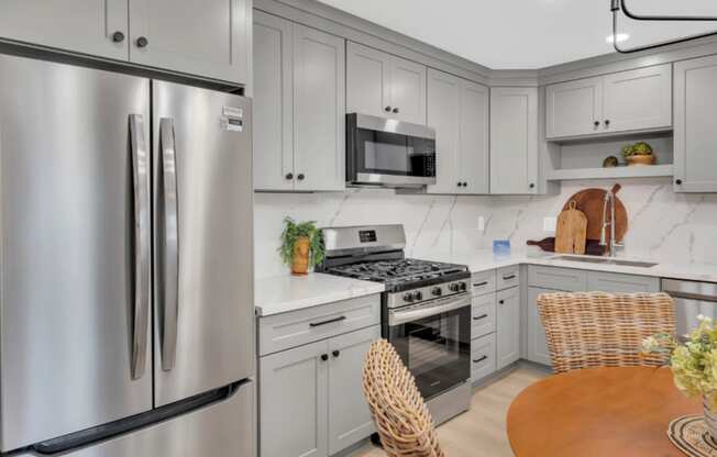 a white kitchen with stainless steel appliances and white cabinetry