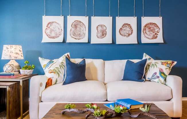 a living room with blue walls and a white couch at Villa Espada Apartments, San Antonio, TX