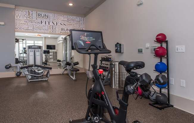 a spacious exercise room with cardio equipment and a treadmill at The Whitworth, Virginia, 23185