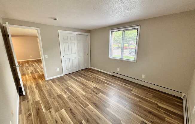 A room with wooden flooring and a window.