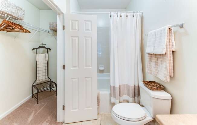 a bathroom with a white toilet and a white shower curtain