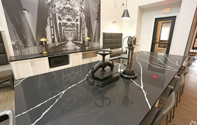 a large kitchen with a black counter top and a dining room table with chairs at Century Baxter Avenue, Louisville, KY 40204