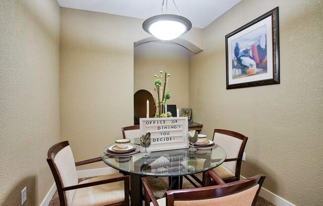 a dining room table with chairs and a chandelier At Metropolitan Apartments in Little Rock, AR