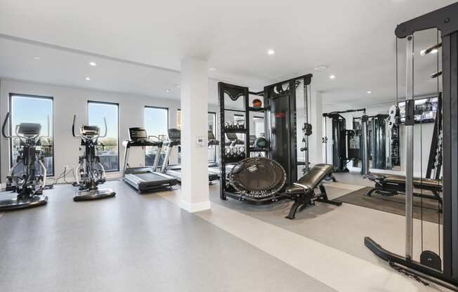 a workout room with weights and cardio equipment in a home gym