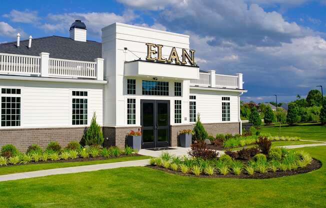 the front of a white building with a sign on top of it