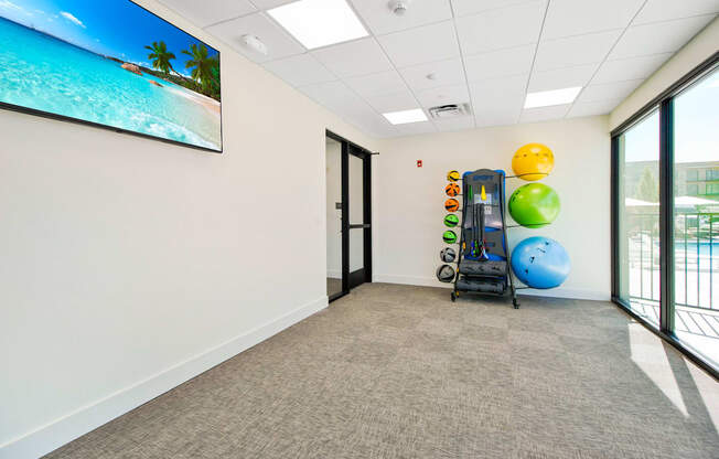 an empty room with a gym with weights and balls on the wall