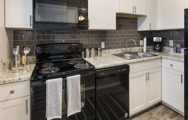 a kitchen with black appliances and white cabinets