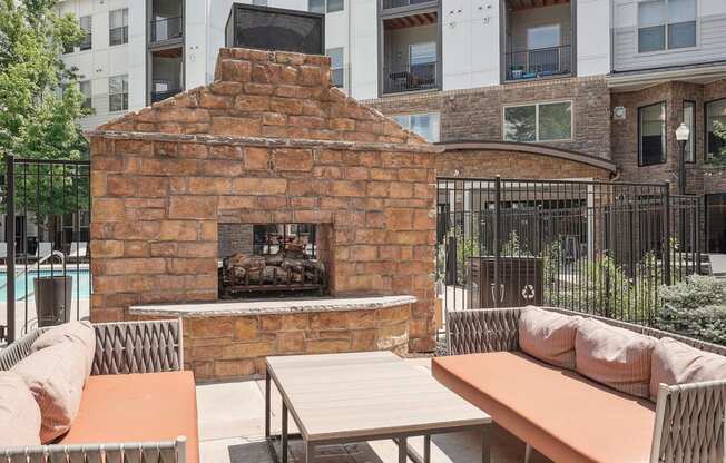 a courtyard with a stone fireplace and tables and chairs