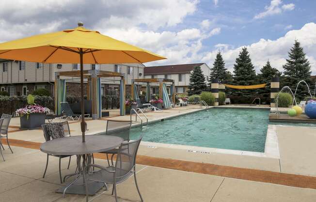 our apartments have a pool and patio with chairs and umbrellas at Village Club of Rochester Hills, Shelby Township, 48317