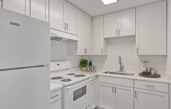 a kitchen with white cabinets and white appliances