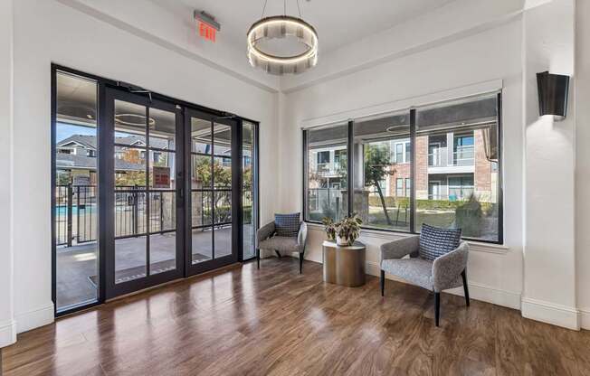 A room with a wooden floor and a grey sofa.