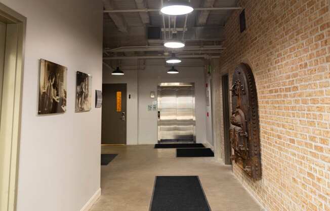 a hallway with brick walls and a rug in the center of the floor