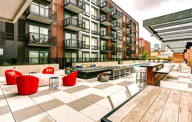 an outdoor patio with tables and chairs at a building with a pool