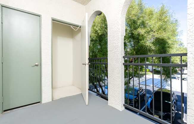 a balcony with a door to a parking lot