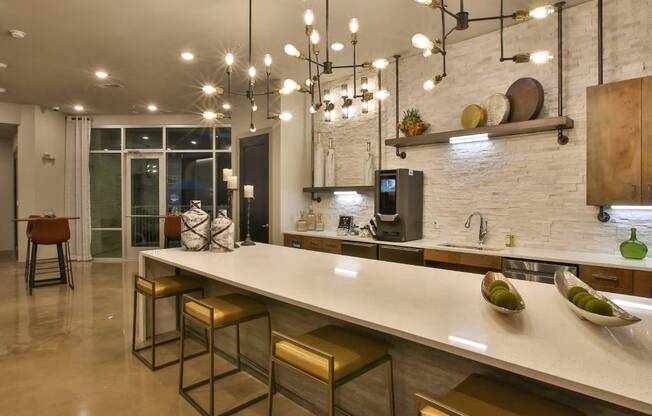 a kitchen with a long counter and chairs