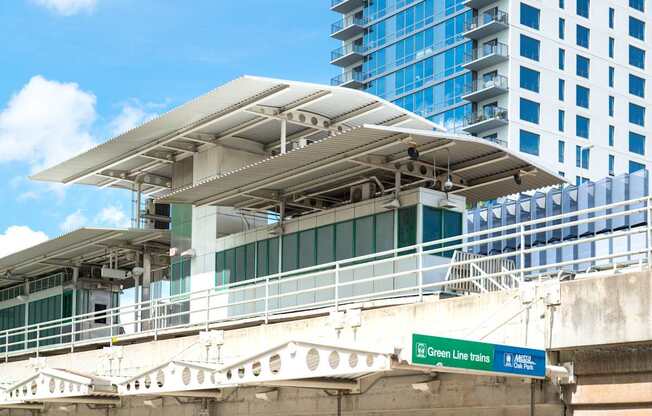 A train station with a green sign that says