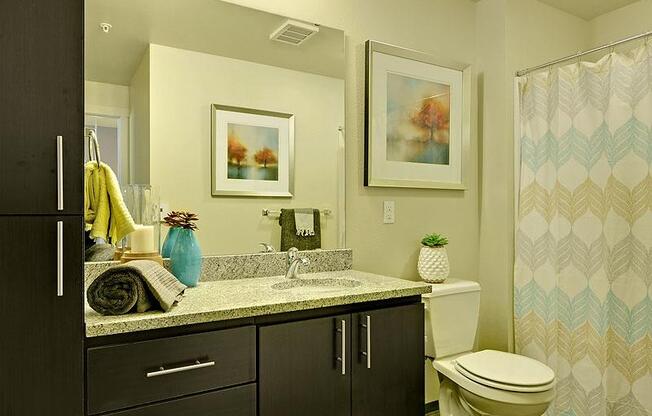 A bathroom with a toilet, sink, and shower. at Kirkland Crossing Apartments, Kirkland, Washington