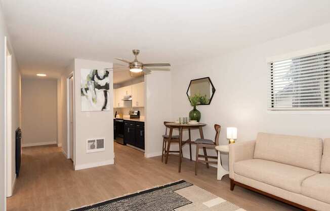 A living room with a couch, a table, and a ceiling fan.