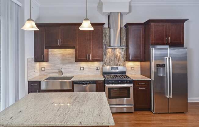 a large kitchen with stainless steel appliances and marble counter tops