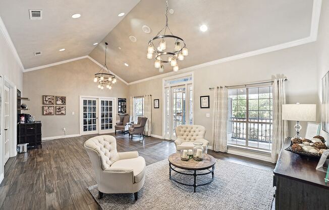 apartment clubhouse with white chairs and a chandelier