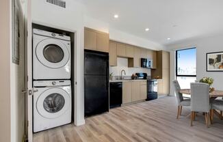 a kitchen and living room with a washer and dryer combo