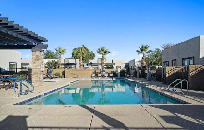 A swimming pool with a slide and palm trees in the background.