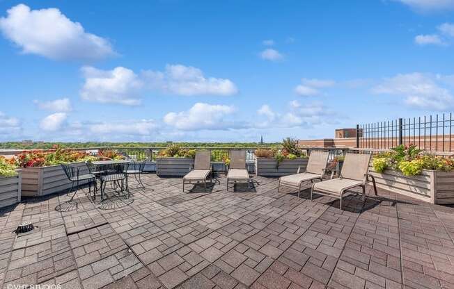 a patio with chairs and tables on a roof
