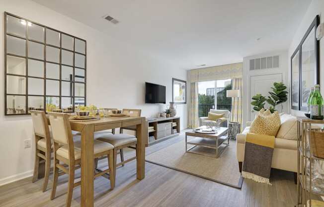 a living room and dining room with a table and chairs