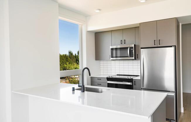 Modern kitchens feature quartz countertops, flat-panel cabinetry, stainless steel appliances, and expansive windows that bring natural light and views of the surrounding landscape indoors.