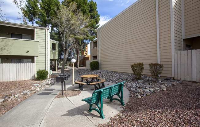 a picnic area with a bench and a table in a courtyard