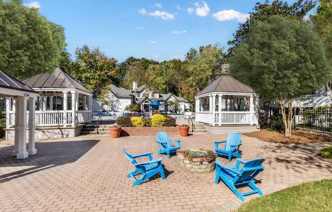 A gazebo surrounded by blue chairs and a brick walkway.