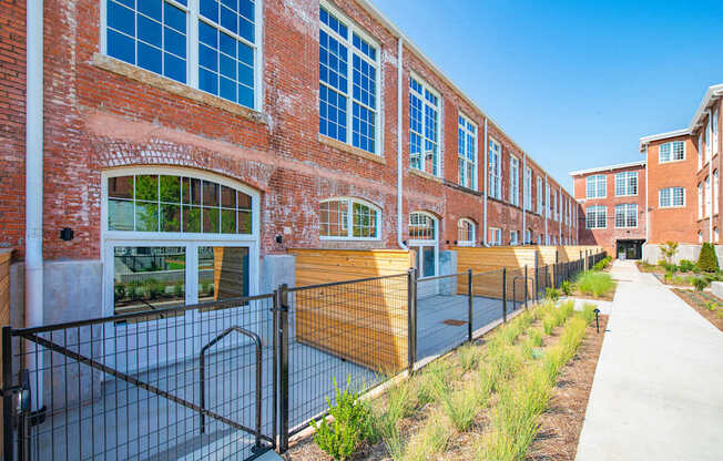 A long brick building with a fence in front.