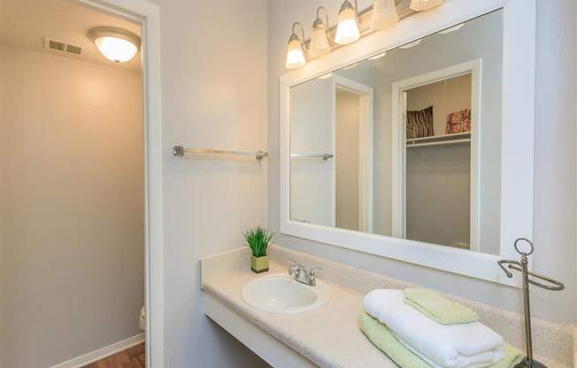 A bathroom with a white sink and a mirror above it.