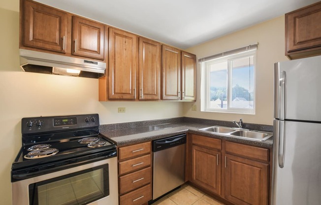 a kitchen with wooden cabinets and stainless steel appliances and a window