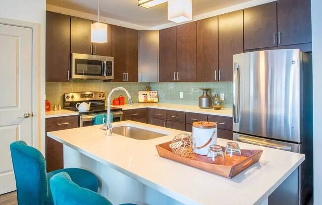 A kitchen with a white countertop and a stainless steel refrigerator.