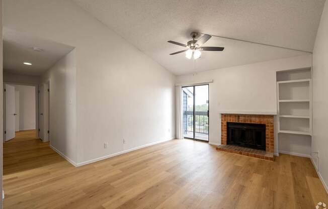 A room with a fireplace and a ceiling fan.