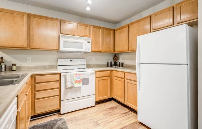 Kitchen with brown cabinetry and stainless steel appliances at Westmont Commons apartments for rent in Asheville, NC