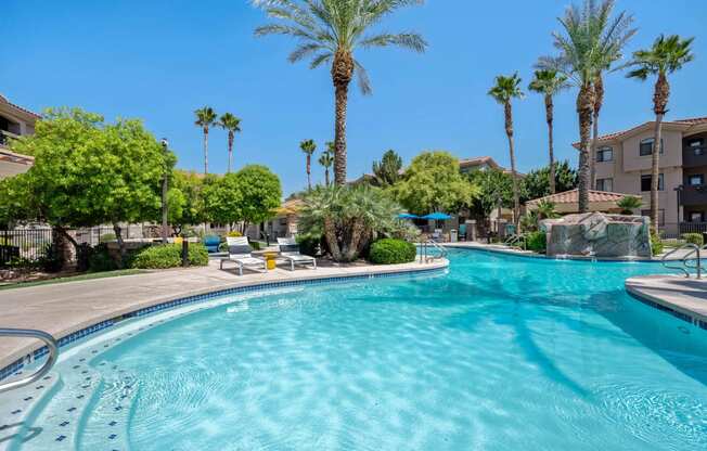 a large swimming pool with lounge chairs and palm trees in tempe arizona